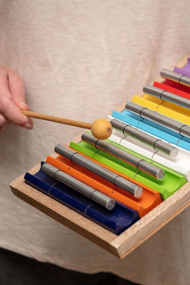 Sound therapist playing on a colorful small hand-held xylophone